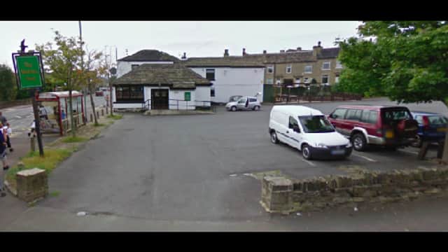 Pay & Display parking area in Brighouse, Yorkshire, with vehicles parked and a building in the background.