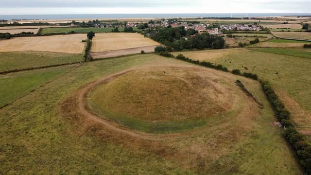 Aerial view of Skipsea Castle mound surrounded by fields and distant coastal landscape in Yorkshire.