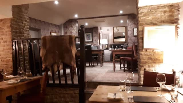 Cozy interior of The Hare Restaurant with wooden tables, stone walls, and elegant dining setup in Old Byland, Yorkshire.