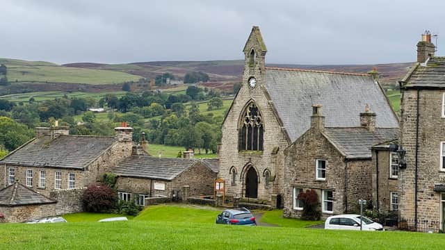 Hudson House, a stone building with a clock tower, surrounded by green fields and quaint Yorkshire cottages.