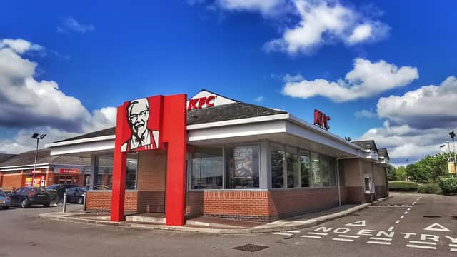 KFC restaurant with a prominent logo, blue sky, and EV charging station in Hunslet Green Retail Centre, Yorkshire.