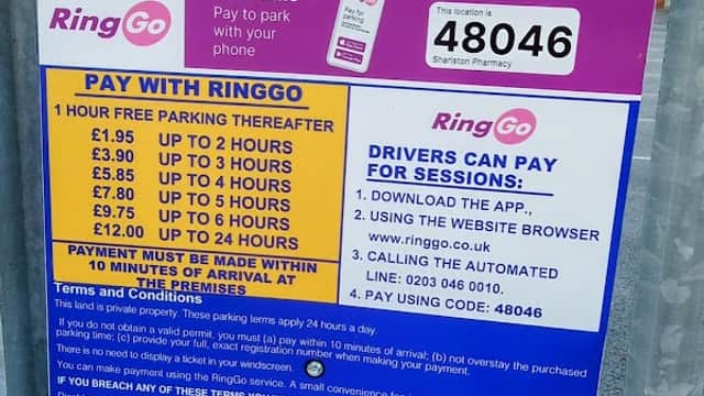 Parking sign detailing Pay & Display rates and payment options at Sharlston Pharmacy Car Park in Kirkthorpe, Yorkshire.