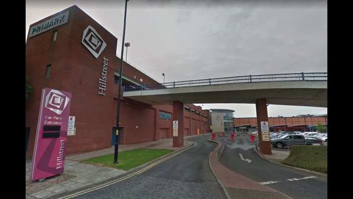 Car park entrance with signage, ramp, and buildings in a shopping area in Middlesbrough, Yorkshire.
