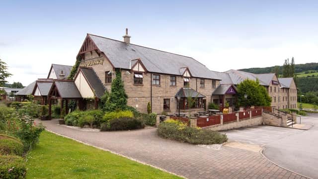Premier Inn Bradford North hotel features a stone exterior, landscaped gardens, and a parking area in a scenic setting.