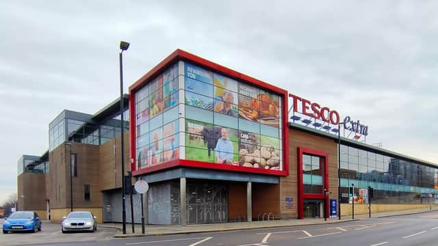 Large Tesco Extra store with modern architecture, featuring colorful advertisements and a parking area in Rotherham.