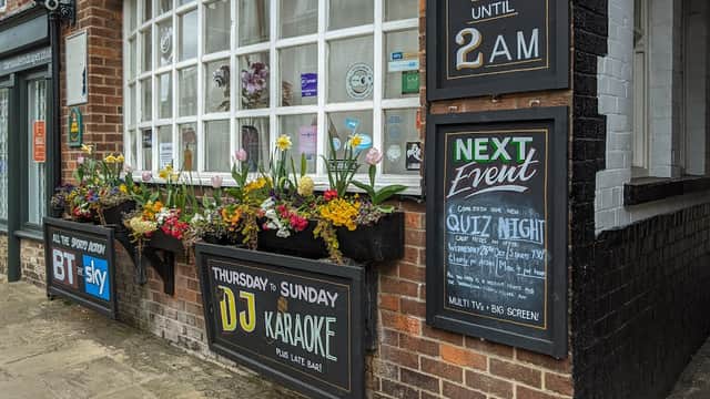 The Beaver pub features flower boxes, event signage, and large windows, inviting guests for karaoke and quiz nights.
