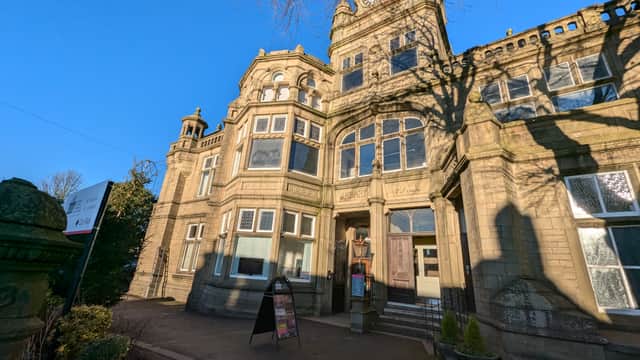 Victorian-style building with ornate stonework and a clock tower, featuring a sign for Glusburn Institute.