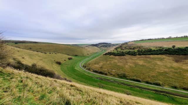 Rolling green hills and a winding road through Millington Pasture, under a cloudy sky in Yorkshire.