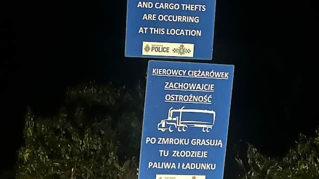 Two blue signs warning HGV drivers about overnight fuel and cargo thefts in Austerfield, Yorkshire.