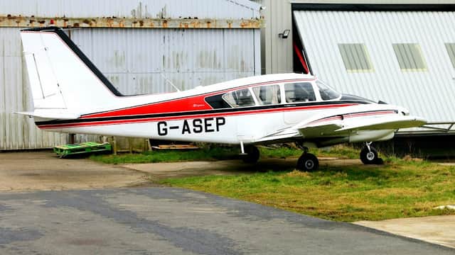 Light aircraft G-ASEP parked on tarmac near hangars at Bagby Airfield, surrounded by grass and buildings.
