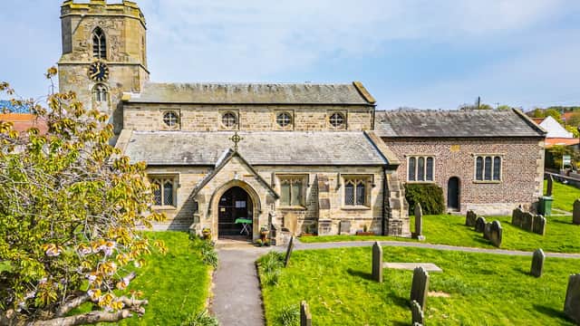 St Michael's Church in Bempton, Yorkshire, featuring stone architecture, a tall clock tower, and a surrounding graveyard.
