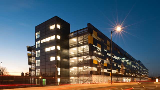 Modern multi-story car park with illuminated windows, streetlights, and a twilight sky in Wakefield, Yorkshire.