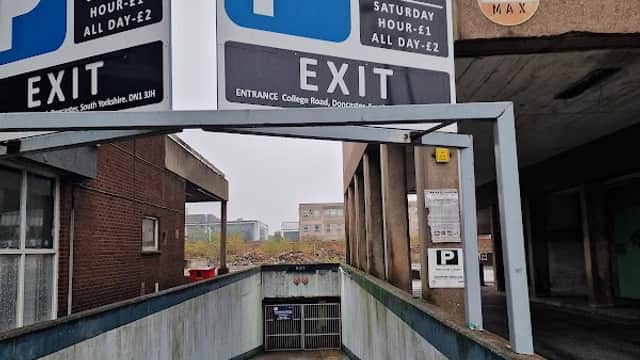 Signage indicating parking rates and exit, with a ramp leading into a multi-story car park in Doncaster.