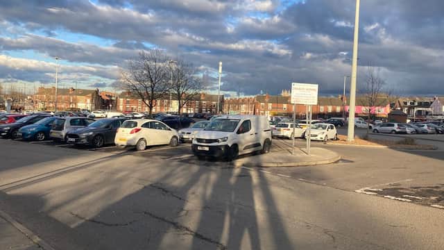 Car park with various vehicles, street lighting, and a cloudy sky in Doncaster, Yorkshire.