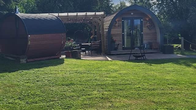 Cozy wooden pods with a patio, surrounded by greenery and trees at Four Wynds Bed and Breakfast in Faceby, Yorkshire.