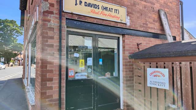 Brick storefront with "J P Davids (Heat It)" sign, featuring a door and window, in Riccall, Yorkshire.