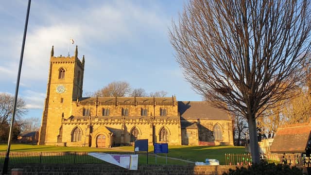 Church Street Car Park with a historic stone church, trees, and a clear blue sky in Rothwell, Yorkshire.