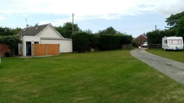 Hotel exterior with grassy area, gravel driveway, hedges, and a parked caravan in Burton Pidsea, Yorkshire.