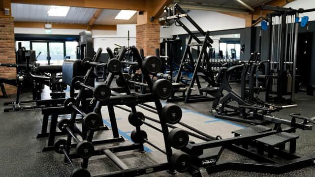 Modern gym interior featuring various weightlifting equipment and free weights in a spacious layout.