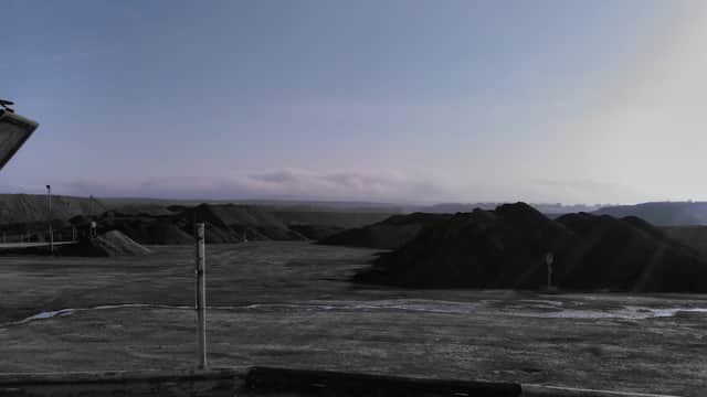 Dusty landscape with large heaps of aggregate material under a clear sky in Preston-Under-Scar, Yorkshire.