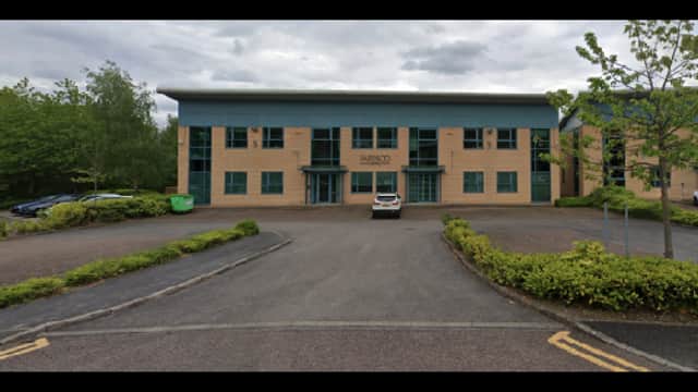 Parking area with a large building, trees, and several parked cars in Chapeltown, Yorkshire.
