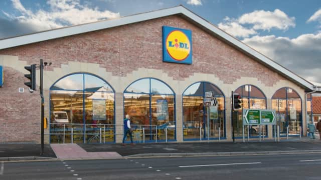 Lidl store in Pickering, Yorkshire, featuring large windows, a blue and yellow logo, and a cloudy sky backdrop.