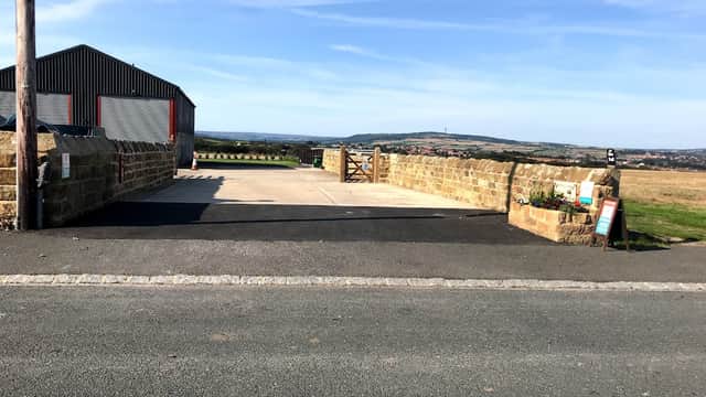 Stone wall entrance to Poverty Cottage CL, with a gravel drive and scenic countryside views in Low Hawsker, Yorkshire.