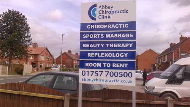 Sign for Abbey Chiropractic Clinic listing services like chiropractic, sports massage, beauty therapy, and reflexology.