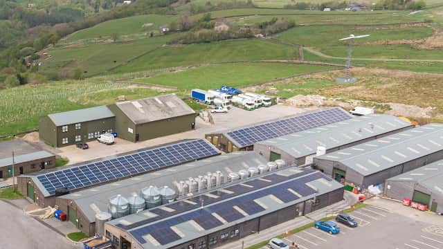 Vocation Brewery with solar panels, surrounded by green hills and parking area in Cragg Vale, Yorkshire.