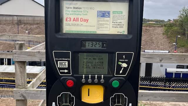 Parking meter at Yarm Station Car Park with payment options and instructions, surrounded by a wooden fence.