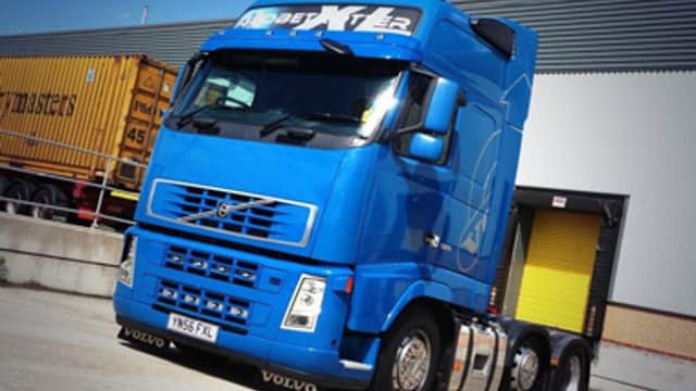Blue Volvo truck with "Max International Transport Ltd" signage parked near a loading dock in Camblesforth, Yorkshire.
