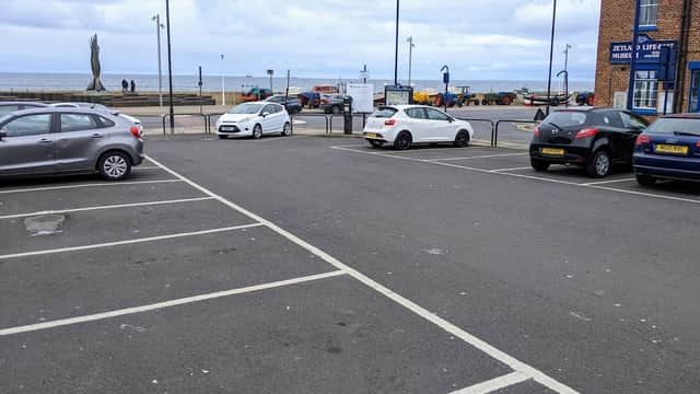 Pay & Display car park with parked cars, sea view, and nearby buildings in Redcar and Cleveland, Yorkshire.