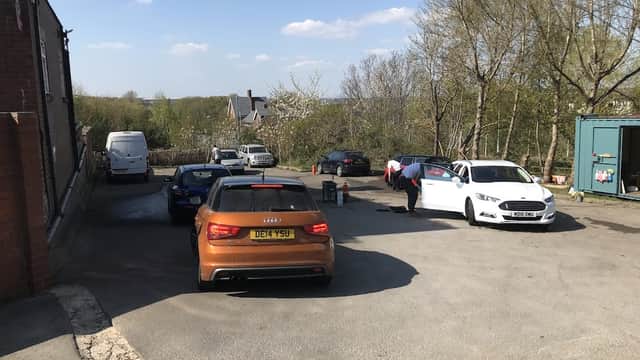 Woodhouse Hand Car Wash with several cars parked and staff washing vehicles under a clear blue sky.