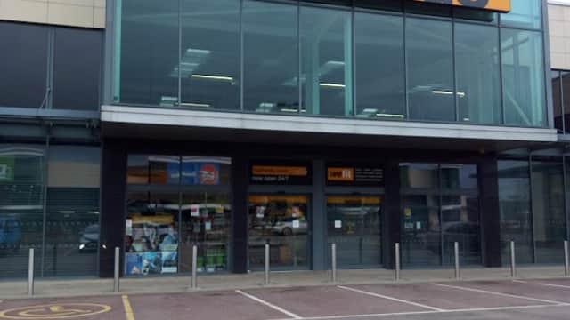 Halfords store front with large orange signage, glass entrance, and parking area in Sheffield, Yorkshire.