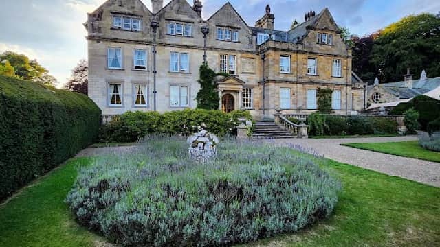 Victorian-style hotel with manicured gardens and lavender, set against a blue sky in Egton Bridge, Yorkshire.