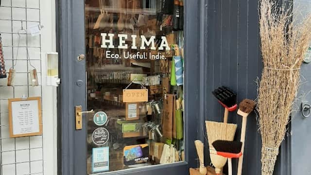 Storefront of HEIMA, featuring eco-friendly homeware, brushes, and a welcoming "OPEN" sign.