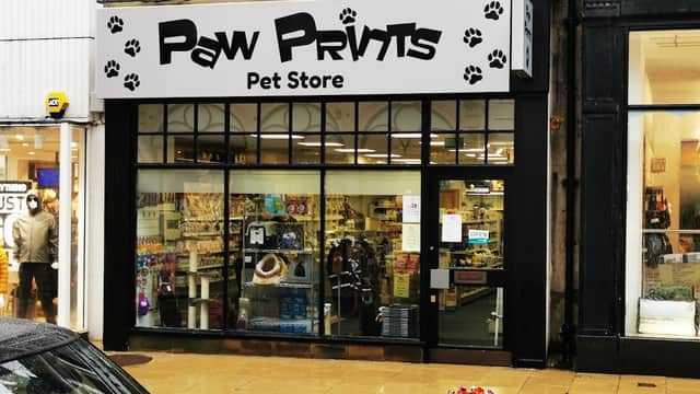 Paw Prints Pet Store storefront with paw print designs, showcasing pet supplies and colorful displays.