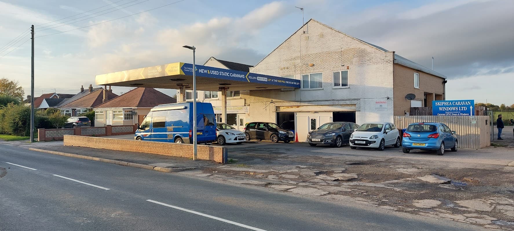 Skipsea Service Station Ltd with several cars parked outside, located on a quiet street in Skipsea, Yorkshire.