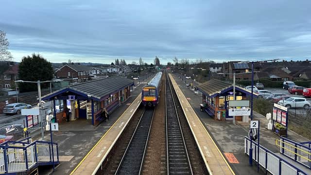Brough Station with two platforms, a train approaching, and a Pay & Display car park in the background.