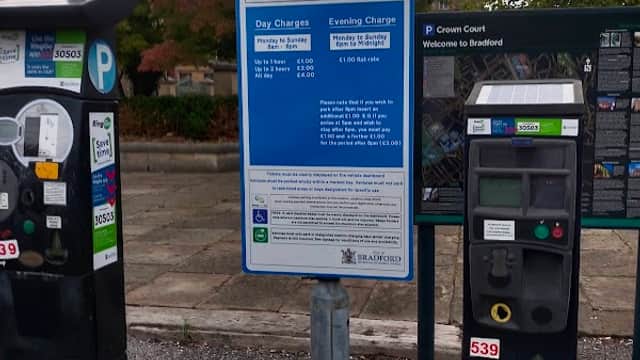 Pay & Display parking meters with a sign detailing charges at Crown Court car park in Bradford, Yorkshire.