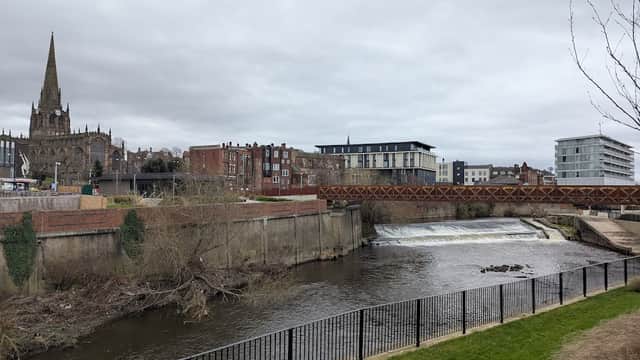 View of Forge Island Car Park with a river, bridge, and buildings, including a church spire in the background.