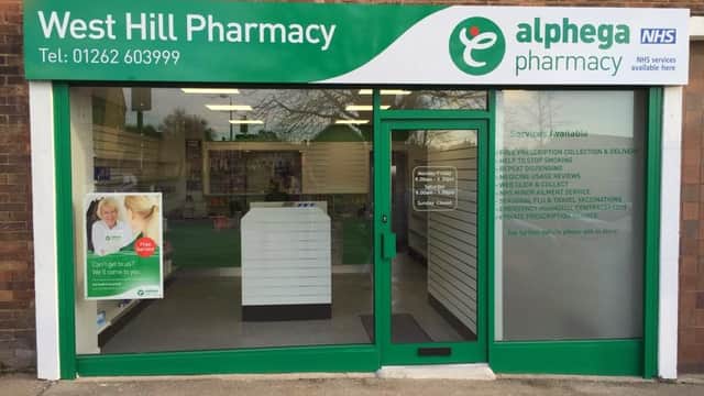 West Hill Pharmacy storefront with signage for ear wax removal, travel, and weight loss services in Bessingby, Yorkshire.