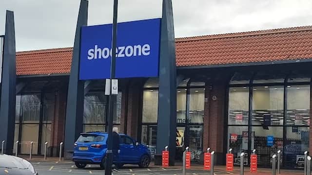 ShoeZone store with a blue sign, modern architecture, and parked cars in front, located in Keighley, Yorkshire.