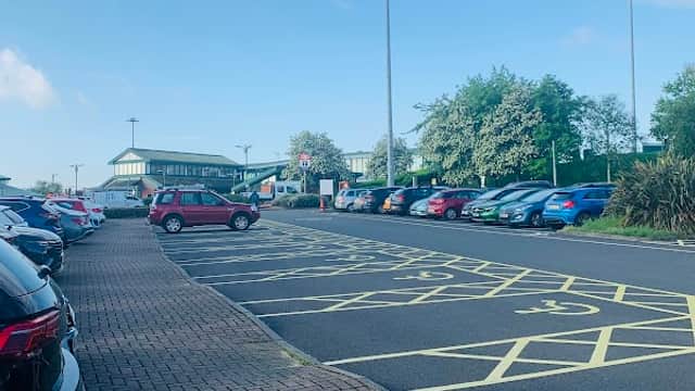 Park & Ride lot with parked cars, clear blue sky, and greenery in the background at Meadowhall, Carbrook, Yorkshire.