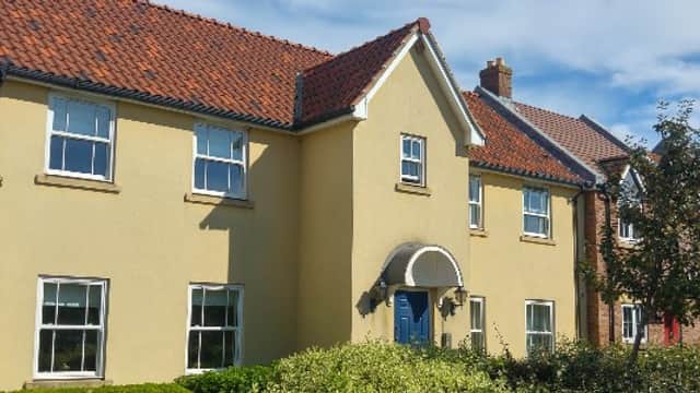 Clara's Den Holiday Apartment features a yellow exterior, red-tiled roof, and landscaped greenery in The Bay, Filey.