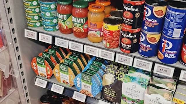 Shelves stocked with various grocery items, including sauces, spices, and canned goods at Londis in Leeming Bar.