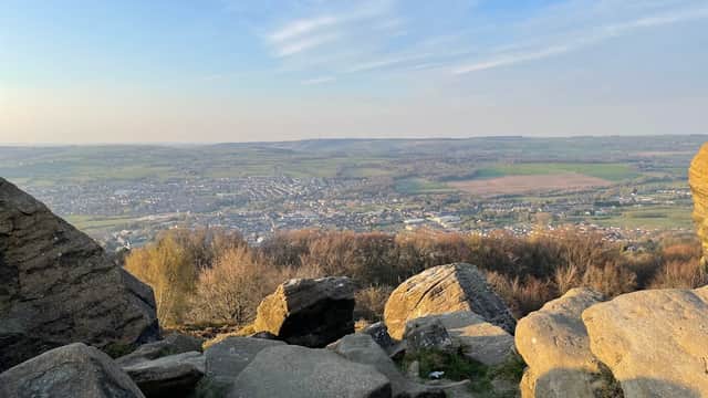 Scenic view from Surprise View Car Park, showcasing rolling hills, a valley, and distant fields under a blue sky.