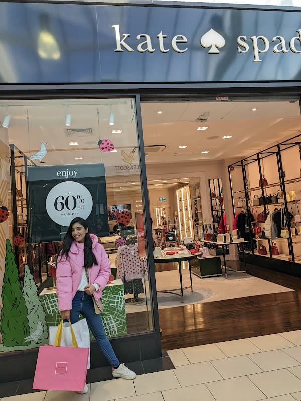SKECHERS Factory Outlet storefront with a bright sign, showcasing shoes and promotional offers.