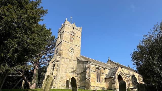 St Hilda's Church in Ellerburn, Yorkshire, features a stone tower, arched windows, and surrounding gravestones.