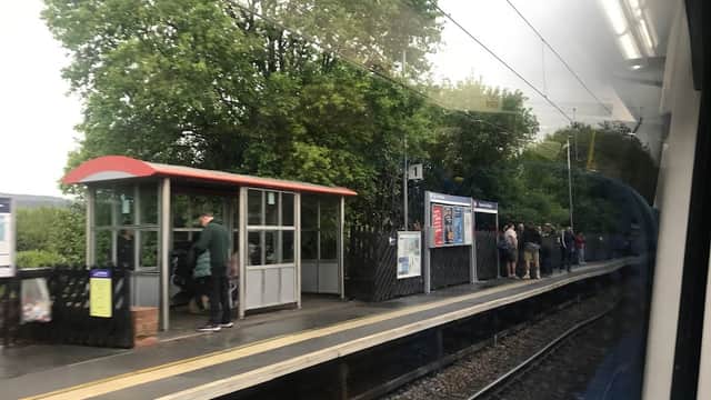 Platform at Steeton & Silsden station with waiting passengers, shelter, and greenery in the background.